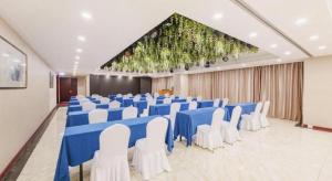a banquet hall with blue tables and white chairs at Dalian Grand Continent International Hotel in Dalian +211 photos
