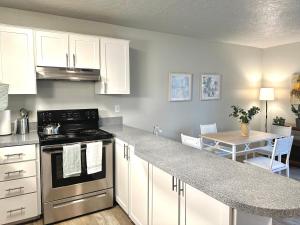 a kitchen with white cabinets and a kitchen counter with a table at Cozy One-Bedroom Haven with Big Balcony in Vancouver