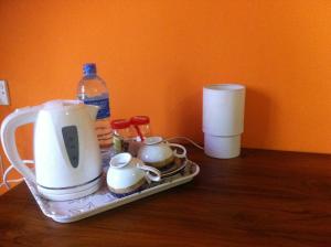 a tray with a tea kettle and cups on a table at Bee Nest Bed & Breakfast in Negombo