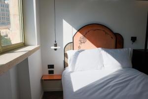 a bedroom with a bed and a window at Jrose Hotel in Jerusalem