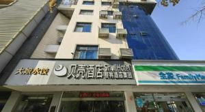 a tall building with a sign in front of it at GreenTree Inn Jiangsu Suzhou Shi Road North Tongjing Road Subway Station Express Hotel in Suzhou