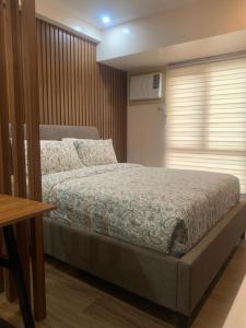 een slaapkamer met een bed, een tafel en een raam bij Centrio Tower New Condo unit 2 in Cagayan de Oro