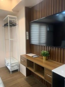 een woonkamer met een grote televisie aan een houten wand bij Centrio Tower New Condo unit 2 in Cagayan de Oro