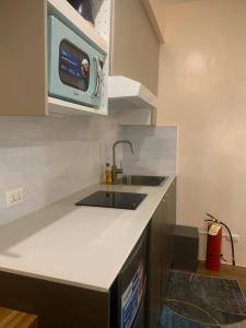 een keuken met een spoelbak en een magnetron bij Centrio Tower New Condo unit 2 in Cagayan de Oro