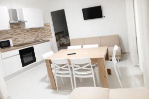 a kitchen with a wooden table and white chairs at MontBliss in Saint Vincent
