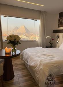 a bedroom with a bed and a view of the pyramids at Lotus signature hotel in Cairo