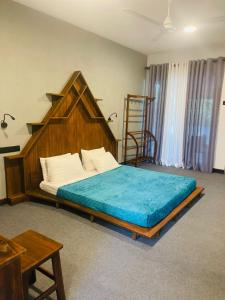een slaapkamer met een groot bed met een groot houten hoofdeinde bij Eleven 11 resort in Tangalle