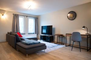 a living room with a couch and a tv at Apartment - 3 guests in Mont-Saint-Guibert