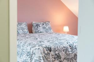 a bedroom with a bed with a blue and white comforter at Apartment - 3 guests in Mont-Saint-Guibert