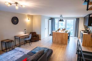 a living room with a couch and a kitchen at Apartment - 3 guests in Mont-Saint-Guibert