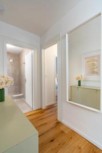 een woonkamer met witte muren en een groot raam bij Vertical Suite Modern 3 Bedroom Apartment near Central Station in Zürich