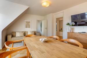 een woonkamer met een houten tafel en stoelen bij Vertical Suite Modern 3 Bedroom Apartment near Central Station in Zürich