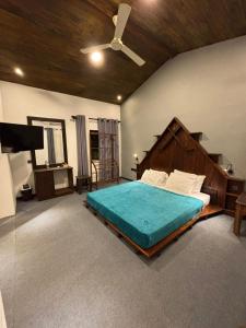 een slaapkamer met een groot bed en een plafondventilator bij Eleven 11 resort in Tangalle