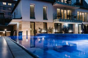 a swimming pool in front of a building at Hotel Auris in Szeged