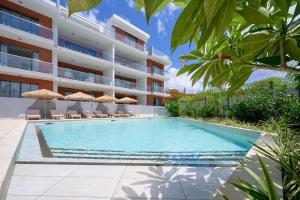 een zwembad voor een gebouw bij Résidence ORYAM B21 in Pointe aux Biches