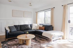 een woonkamer met een zwarte bank en een salontafel bij Whitsunday Wanderluxe in Cannonvale