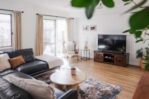 een woonkamer met een bank en een tv bij Whitsunday Wanderluxe in Cannonvale +20 foto's