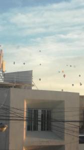 a bunch of kites flying in the sky over a building at Casagrande in San José de Malpaso