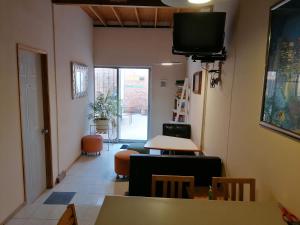 a living room with a tv and a table and chairs at Casagrande in San José de Malpaso