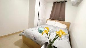 een slaapkamer met een bed en een vaas met gele bloemen bij warm heart toronto in Toronto
