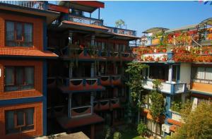 um edifício de apartamentos com plantas nas varandas em Boudha Orange Hotel em Catmandu