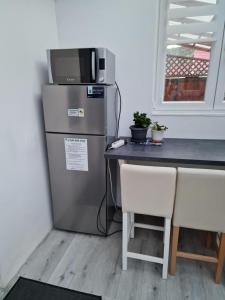 a kitchen with a refrigerator and a table with two chairs at Családi haz in Budapest