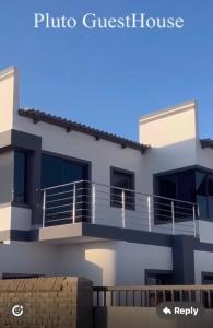 a house with a balcony and a villa at Pluto Guesthouse in Walvis Bay