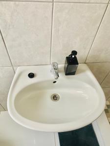 a bathroom sink with a soap dispenser on top of it at Pluto Guesthouse in Walvis Bay