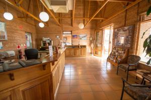 a kitchen with a counter and chairs in a room at Mud Hut Motel in Coober Pedy