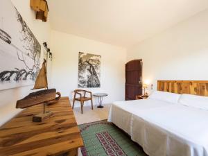 een slaapkamer met een bed, een tafel en een stoel bij Can Piedrópolis in Cala Saona