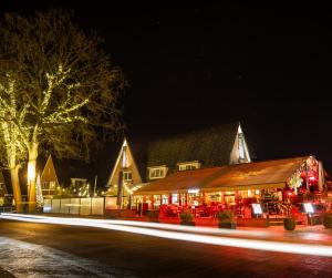 韦斯特博克Boutique Hotel, Restaurant & Wellness Westerburcht的晚上亮着圣诞灯的建筑物