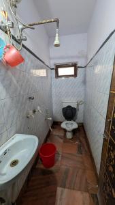 a small bathroom with a toilet and a sink at Ashirbad hotel in Digha