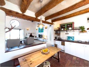 een keuken met witte kasten en een houten tafel bij Can Piedrópolis in Cala Saona