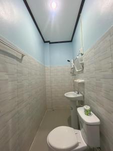 a bathroom with a white toilet and a sink at VangVieng Smile guesthouse in Vang Vieng