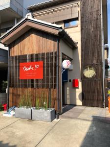 een gebouw met een uithangbord aan de zijkant bij Guesthouse Nobi in Kyoto