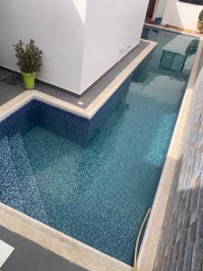 a swimming pool with blue water in a building at Maison de vacance Saly in Mbour