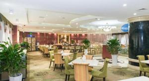 a dining room with tables and chairs in a restaurant at Dalian Liangyun Hotel in Dalian