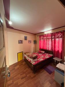 a bedroom with a bed and red curtains at V V Homestay in Darjeeling