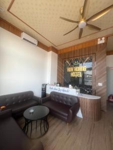 a living room with a couch and a ceiling fan at Huy hoang hotel 
