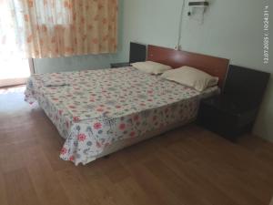 a bedroom with a bed with a floral comforter at Бунгала Дъбрава in Shkorpilovtsi +13 photos