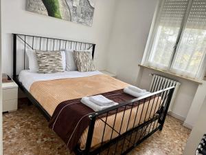 een slaapkamer met een bed met een zwart metalen frame bij Confortini Rooms SUNDAY in Verona