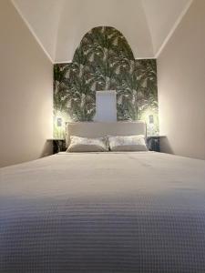 een slaapkamer met een groot bed met tropisch behang bij Civico 27 in Ostuni
