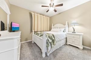 una camera con letto bianco e ventilatore a soffitto di Beach Club Condos a Gulf Shores