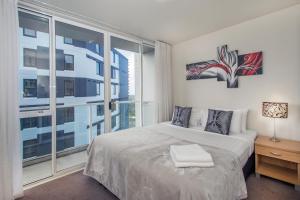 a bedroom with a bed and a large window at Crown on Cintra Lane in Auckland