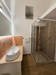 een badkamer met een glazen douche en een wastafel bij Civico 27 in Ostuni +13 foto's