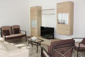 ein Wohnzimmer mit einem Sofa und einem TV in der Unterkunft Villetta Angela in Torre San Giovanni Ugento