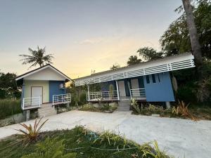 a blue and white house with a palm tree at ต้นตาล&ตาลฟ้า รีสอร์ท in Ban Nong Khang