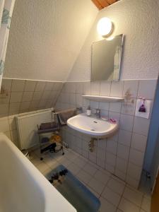 une salle de bains avec lavabo, miroir et baignoire dans l'établissement Appartement in Düsseldorf, à Düsseldorf