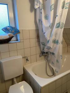 La salle de bains est pourvue d'une baignoire, de toilettes et d'un rideau de douche. dans l'établissement Appartement in Düsseldorf, à Düsseldorf