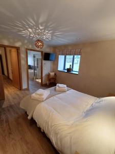 a bedroom with a large white bed with a ceiling at Auld Hoose in Kirkwall